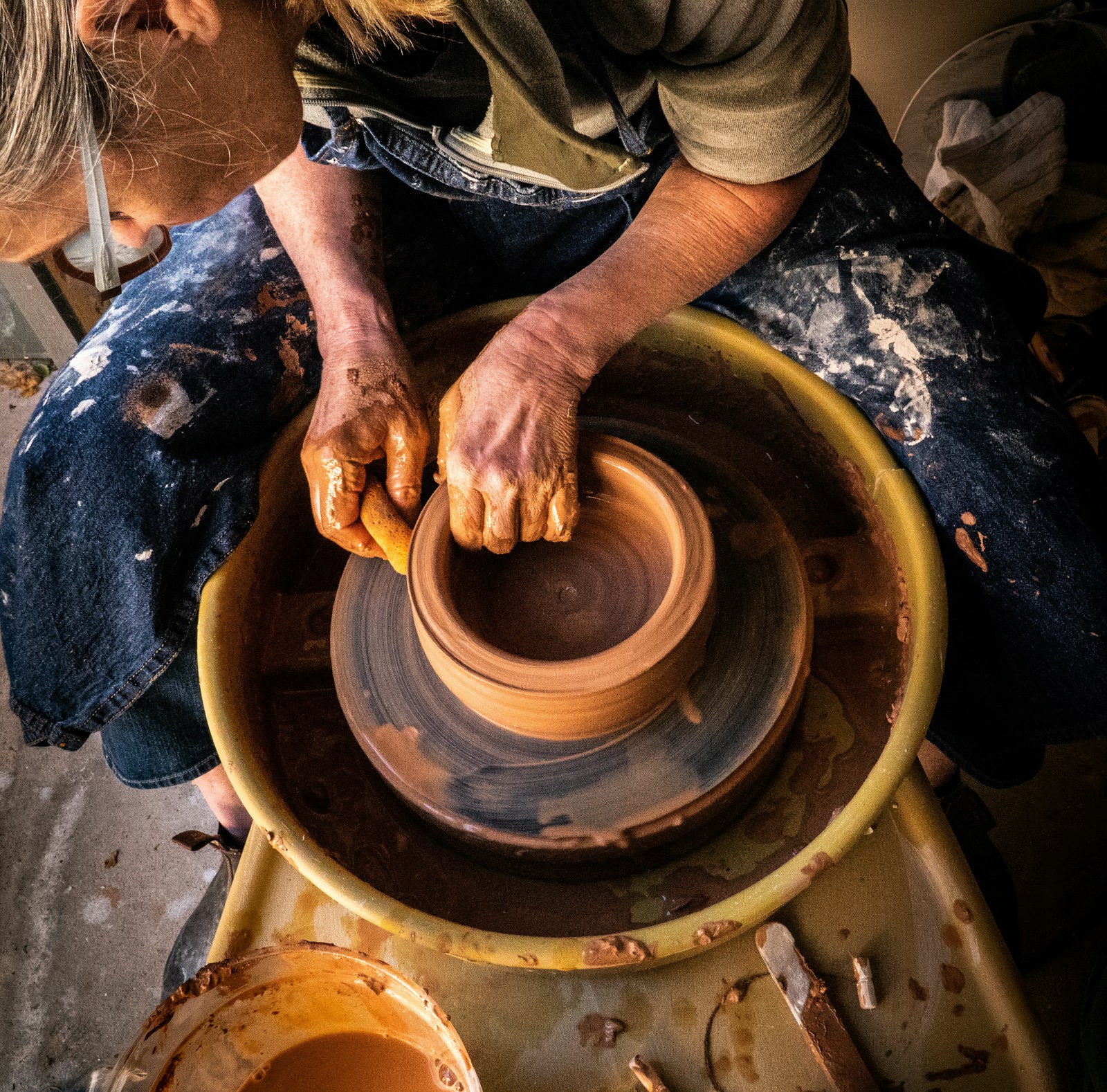 Artisan shaping clay on pottery wheel